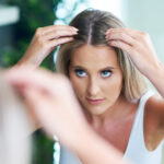 Adult woman searching scalp for hair loss