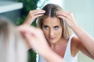 Adult woman searching scalp for hair loss