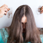 Girl holding her lost hair in hands, on a white background